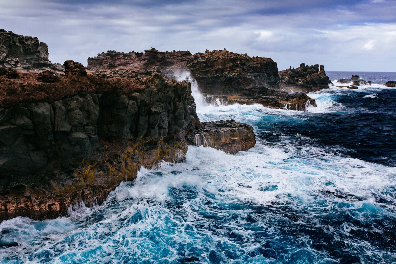 Rugged volcanic coastline with crashing waves